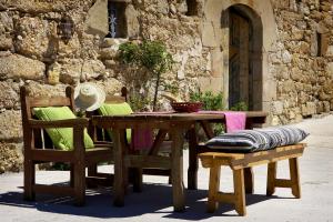 una mesa de madera con 2 sillas y una mesa con un tazón. en Poble Rural Puig Arnau - Pubilló, en Odèn