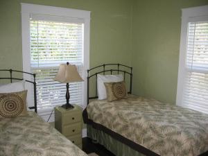 um quarto com 2 camas e 2 janelas em Historic Cottage With Private Pool! Home em West Palm Beach