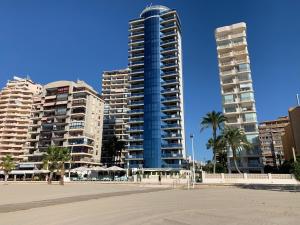 two tall buildings in a city with palm trees at Vista Bella Apartment in Calpe