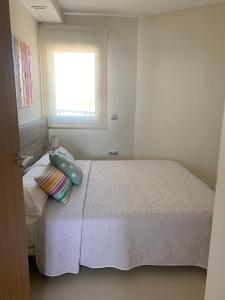 a bedroom with a white bed with a window at Vista Bella Apartment in Calpe