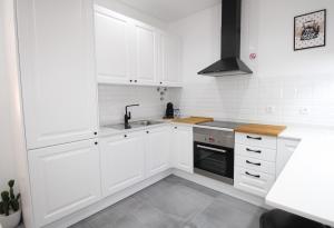 a white kitchen with white cabinets and a sink at Apartamento Moderno nas Olaias a 5 minutos da Faculdade ISEL e IST in Lisbon