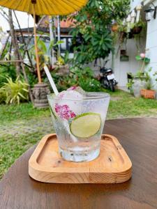 een drankje met limoen in een glas op een houten blad bij Elliebum Boutique Hotel in Chiang Mai