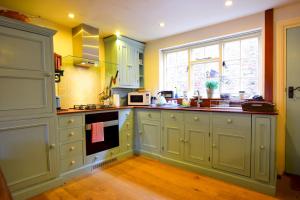 a kitchen with yellow walls and white cabinets at 7 Monk Bar Court YORK in York