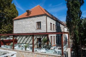 an old stone house with a terrace and chairs at Integra Hotel in Trebinje