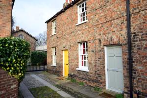 a brick building with a yellow door on it at 7 Monk Bar Court YORK in York