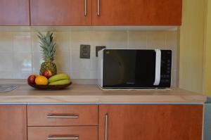 una encimera de cocina con microondas y un bol de fruta en Ubytování u lípy, en Náchod