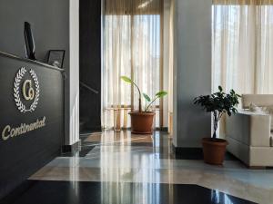 a lobby with potted plants and a sign on the wall at Continental Hotel in Kutaisi