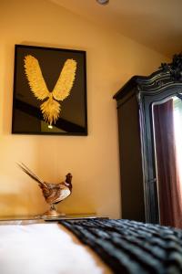 a bird sitting on a bed with a picture of a butterfly at Frasers in Egerton