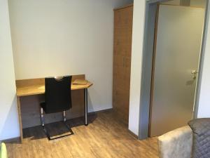 Habitación pequeña con escritorio y silla. en Appartements Schwarzer Adler en Elbigenalp