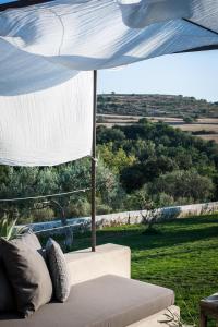 a couch sitting under a tent with a view of a field at Dimora delle Balze in Noto