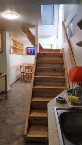 eine Treppe in einem Zimmer mit einer Küche und einem Tisch in der Unterkunft Къща Корона in Warna
