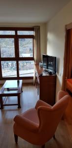 a living room with a couch and a desk and a television at Soldeu Paradis Pleta in Soldeu