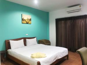 a bedroom with a large bed with blue walls at บ้านพระจันทร์ รีสอร์ท in Ban Khok Sawang (1)