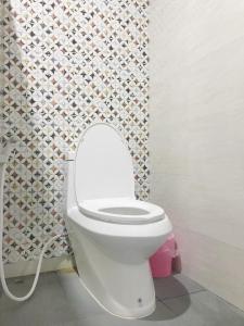 a white toilet in a bathroom with a mosaic wall at บ้านพระจันทร์ รีสอร์ท in Ban Khok Sawang (1)