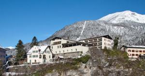 een groep gebouwen aan de zijkant van een berg bij Schlosshotel Dörflinger in Bludenz