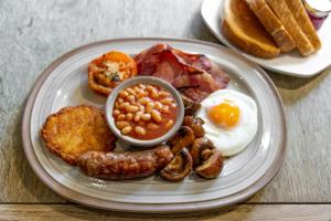 a plate of breakfast food with eggs sausage beans and toast at The Marine in Whitstable
