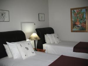 une chambre d'hôtel avec deux lits et une lampe dans l'établissement Forestview guesthouse and B&B, à Sedgefield