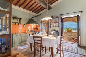 a kitchen with a table and chairs and a kitchen with a view at Agriturismo Etrusco in Murlo