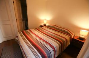 a small bedroom with a bed with two lamps on it at Dpto 1D 1B, Metro Bellas Artes, equipado full con WiFi in Santiago