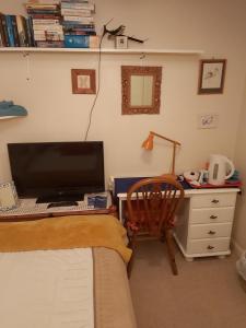 a bedroom with a desk with a computer and a chair at Homely Haven, Dunfermline in Dunfermline