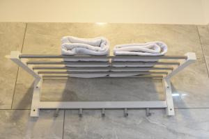 wieszak z białymi ręcznikami na górze podłogi w obiekcie Ville Vesuviane w mieście San Giorgio a Cremano