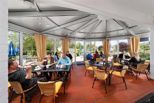 a group of people sitting at tables in a restaurant at KNAUS Campingpark Eschwege in Eschwege