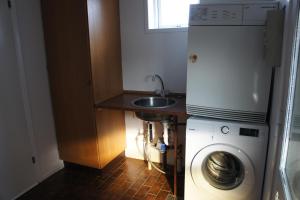 una pequeña cocina con fregadero y lavadora en id. 011. Jagtvej 50 a en Esbjerg