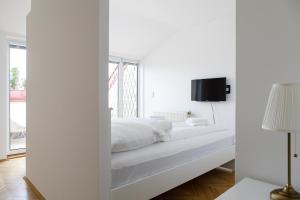 een slaapkamer met witte muren en een bed met een spiegel bij Vienna-flats | contactless check-in in Wenen