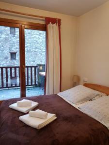 a bedroom with a bed with two towels on it at Soldeu Paradis Tarter Mig in El Tarter