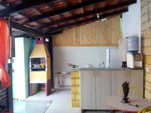 a kitchen with a counter and a table in a room at Hospedaria Casa do Sol - divisa Caraguá e São Sebá in Caraguatatuba