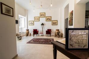 ein Wohnzimmer mit einem Tisch und roten Stühlen in der Unterkunft Nerello Suites and Rooms in Catania