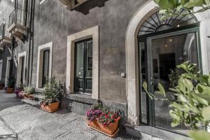 ein Gebäude mit Topfpflanzen nebeneinander in der Unterkunft Nerello Suites and Rooms in Catania