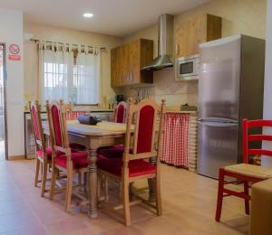 a kitchen with a table and chairs and a refrigerator at Casa Los 5 Caños in Sotillo de la Adrada