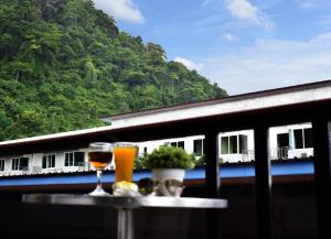 a person sitting at a table in front of a train at Chongkhao Resort- SHA Certified in Phi Phi Islands