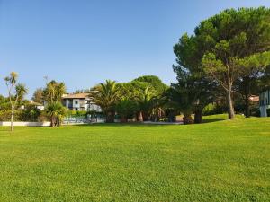 a park with green grass and palm trees and a building at appartement domaine de Bordaberry Urrugne in Urrugne