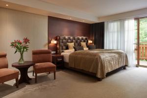 - une chambre avec un lit, une table et des chaises dans l'établissement Hotel Singer, à Ludvíkov