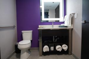 a bathroom with a toilet, sink and mirror at La Quinta by Wyndham Branson in Branson