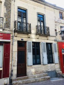 a building with windows and a door on a street at La Rénovée d’Antan in Avallon