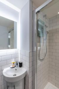 a white bathroom with a sink and a shower at Apt 3, 71 Micklegate, YORK in York