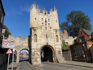 an old stone building with a gate in a street at Apt 3, 71 Micklegate, YORK in York