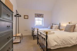 a bedroom with two beds and a window at Trinity Cottage, YORK in York