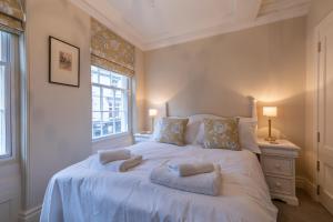 a bedroom with a large white bed with two windows at Apt 3, 71 Micklegate, YORK in York