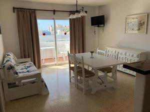 a dining room with a table and chairs and a window at Apartamentos Alba in San Antonio Bay
