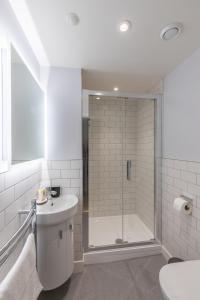 a white bathroom with a shower and a sink at Apt 3, 71 Micklegate, YORK in York
