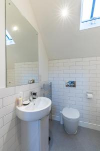 a white bathroom with a sink and a toilet at Trinity Cottage, YORK in York