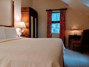 a hotel room with a bed and a lamp at The Inn at Montchanin Village & Spa in Montchanin