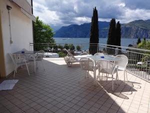 un patio con tavoli, sedie e vista sull'acqua di B&B Casa Gabriele a Malcesine