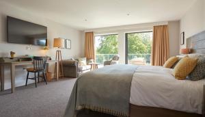 a hotel room with a bed and a desk and a living room at The Swan, Streatley, Berkshire in Streatley
