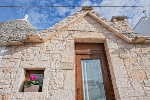 a building with a window with a flower pot on it at IL TRULLO GENTILE ALBEROBELLO in Alberobello