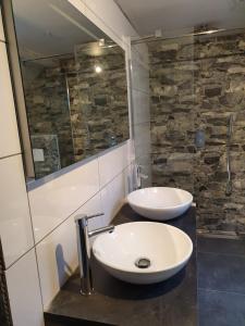 a bathroom with two white sinks and a shower at Maison de gesves in Gesves